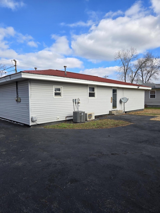 back of property with central air condition unit and ac unit