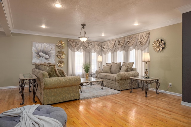 living room featuring a textured ceiling, light wood-type flooring, and ornamental molding