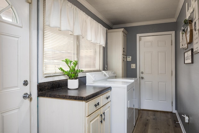 laundry area featuring cabinets, dark hardwood / wood-style flooring, washing machine and dryer, and ornamental molding