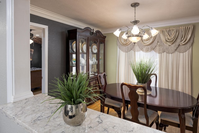 dining area featuring crown molding, hardwood / wood-style flooring, and a notable chandelier