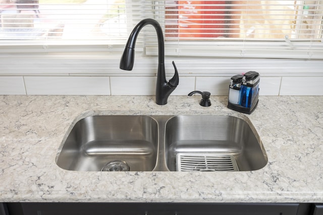 details featuring light stone counters and sink