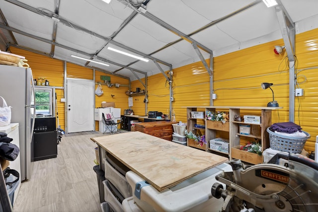 garage featuring white refrigerator and wooden walls