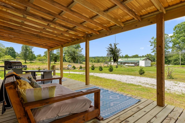 wooden terrace featuring a lawn, a rural view, and grilling area