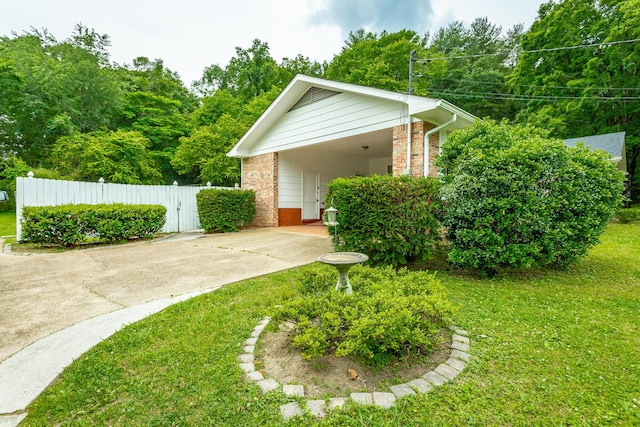 view of side of property with a carport and a lawn