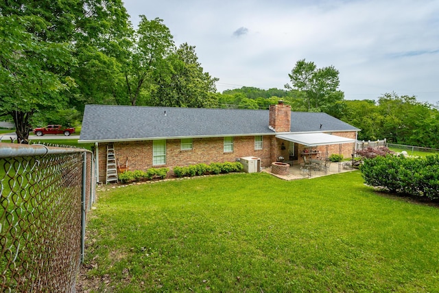 rear view of house featuring a lawn and a patio area