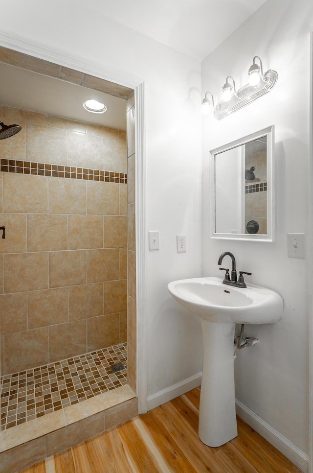 bathroom with hardwood / wood-style floors and a tile shower