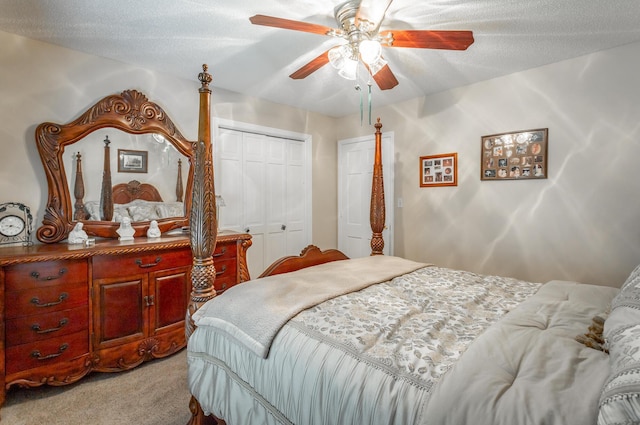 bedroom with ceiling fan, light colored carpet, a textured ceiling, and a closet