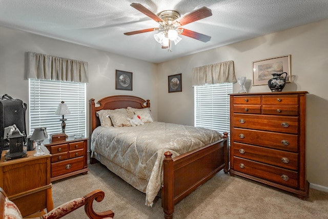 carpeted bedroom featuring ceiling fan and a textured ceiling