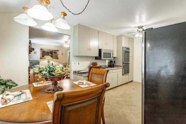 kitchen with a chandelier, hanging light fixtures, stainless steel appliances, and a textured ceiling