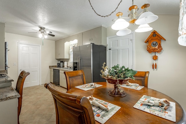 dining room with a textured ceiling, sink, and ceiling fan with notable chandelier