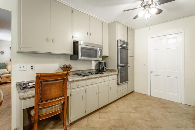 kitchen with multiple ovens, ceiling fan, and gas stovetop