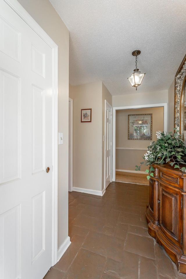 hallway with a textured ceiling