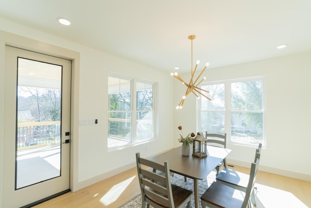 dining space featuring a notable chandelier, light hardwood / wood-style floors, and plenty of natural light