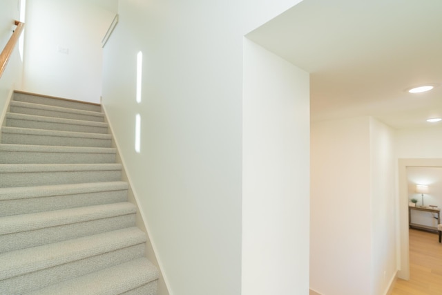 stairs featuring hardwood / wood-style floors