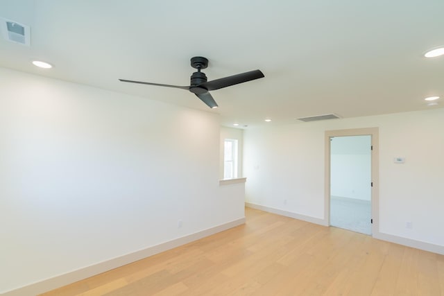 spare room with ceiling fan and light wood-type flooring