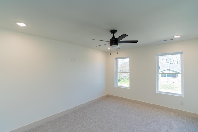 carpeted spare room with ceiling fan