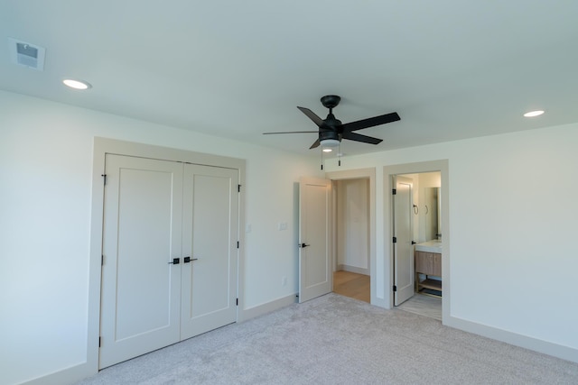 unfurnished bedroom with light carpet, a closet, ensuite bath, and ceiling fan