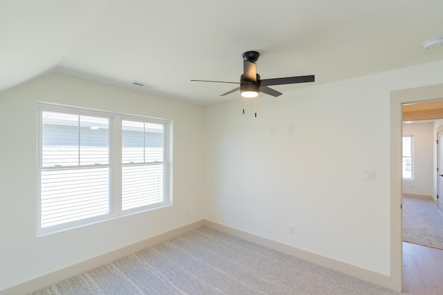 spare room featuring vaulted ceiling, a wealth of natural light, and ceiling fan