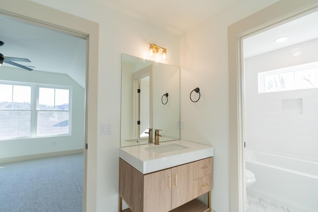 bathroom with vanity, ceiling fan, toilet, and a bath