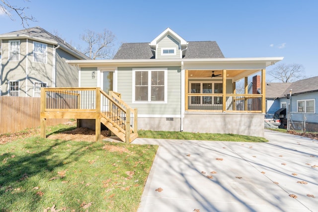 back of property featuring a lawn, a sunroom, and ceiling fan