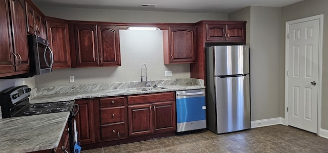 kitchen with visible vents, a sink, appliances with stainless steel finishes, baseboards, and dark brown cabinets