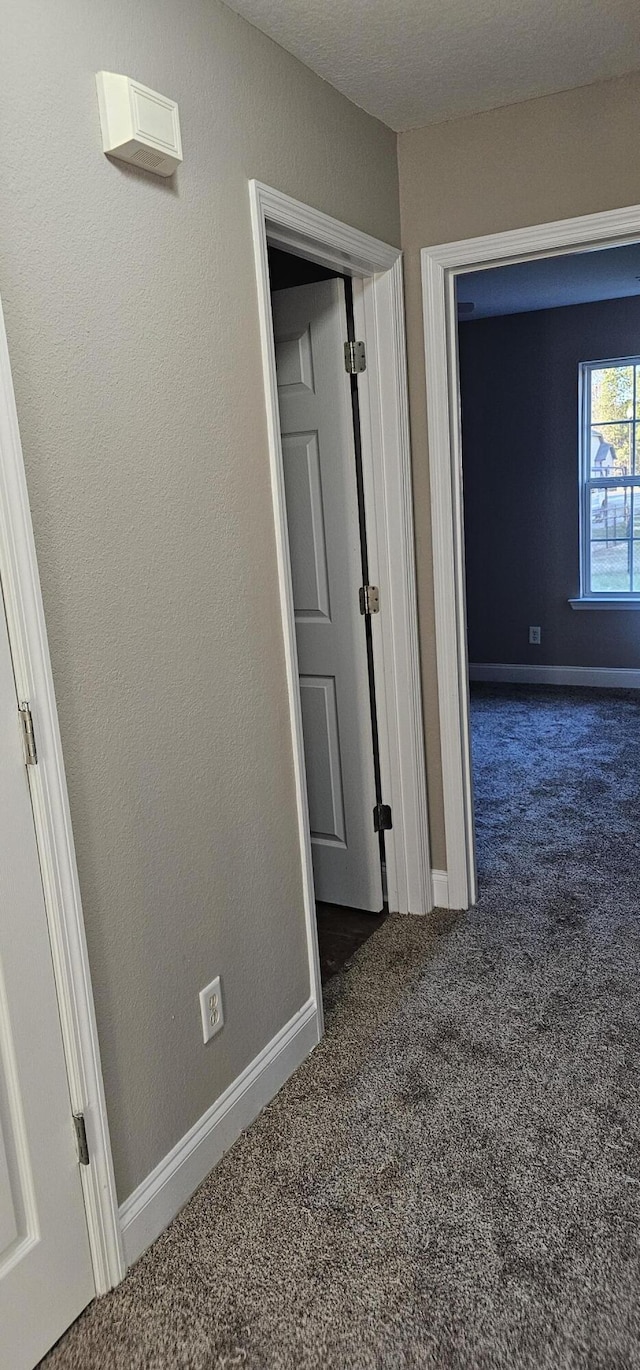 corridor with carpet and baseboards