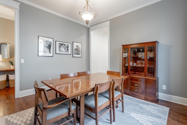 dining room featuring crown molding and dark hardwood / wood-style flooring