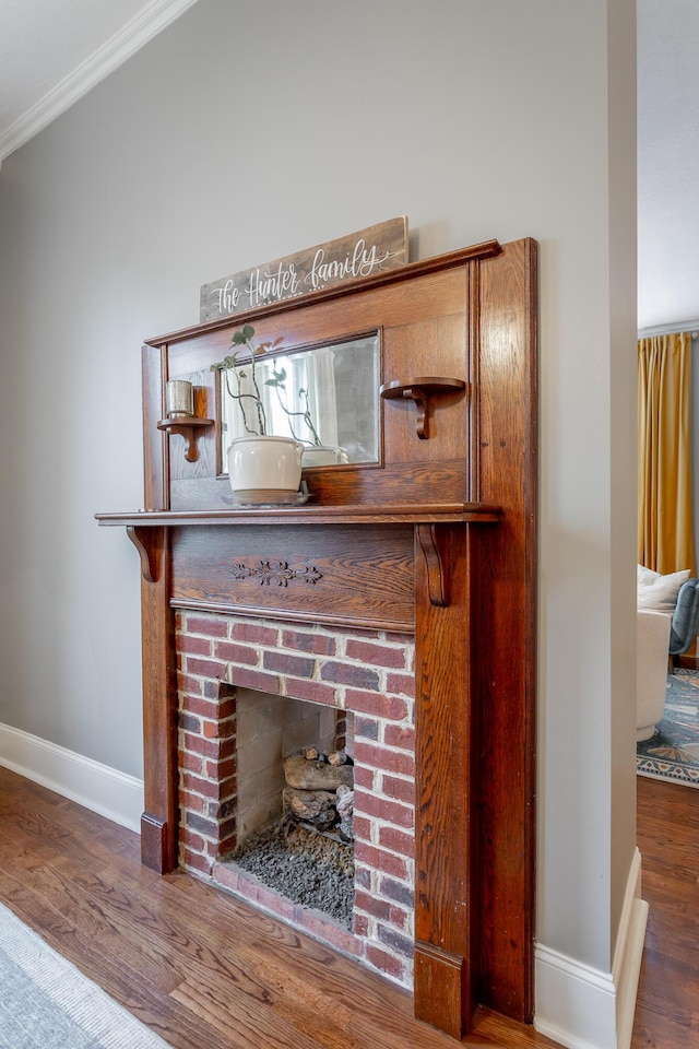 interior details featuring wood-type flooring, a brick fireplace, and ornamental molding