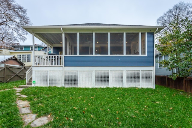 back of property featuring a sunroom and a yard