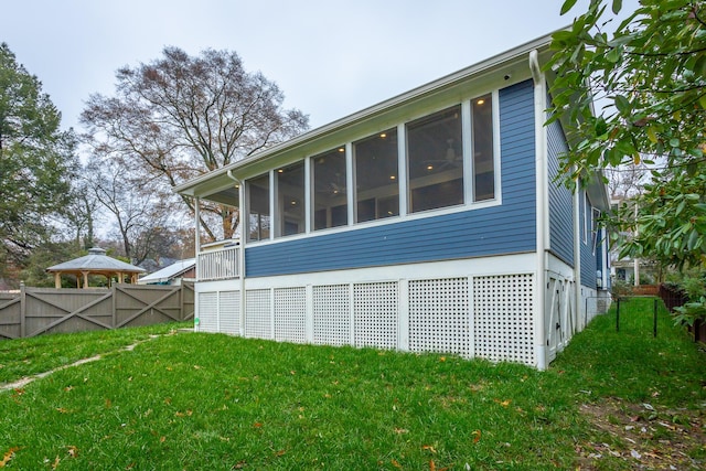 view of side of property featuring a sunroom and a yard