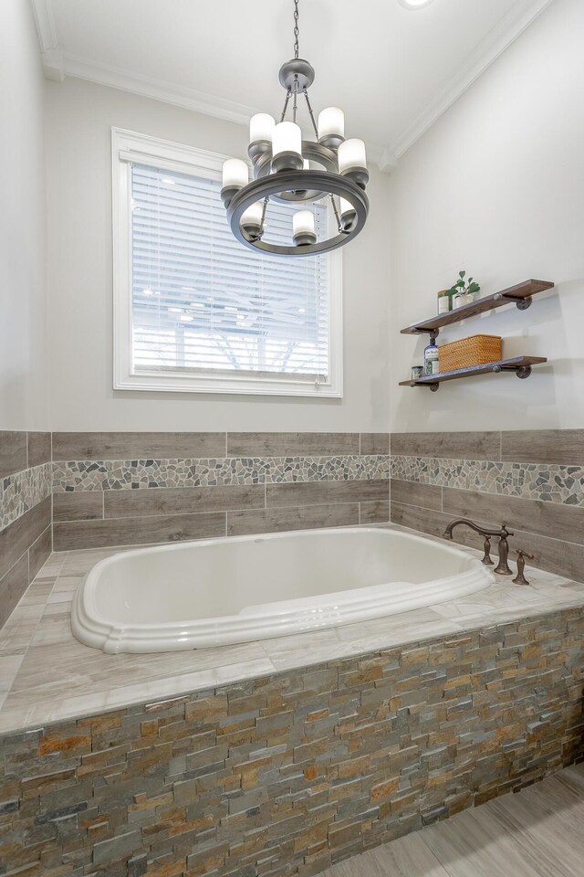 bathroom featuring crown molding, a relaxing tiled tub, and a notable chandelier