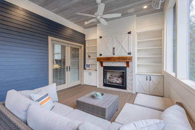 living room featuring french doors, ceiling fan, wooden walls, wood-type flooring, and wooden ceiling