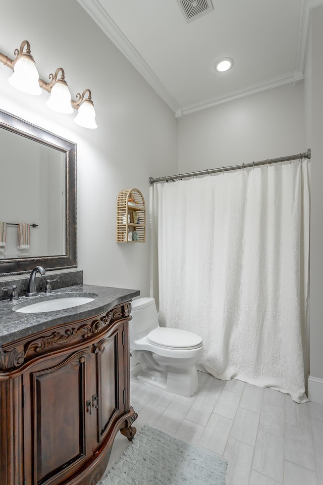 bathroom featuring vanity, toilet, and ornamental molding