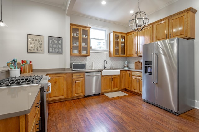 kitchen featuring decorative backsplash, hanging light fixtures, stainless steel appliances, and sink