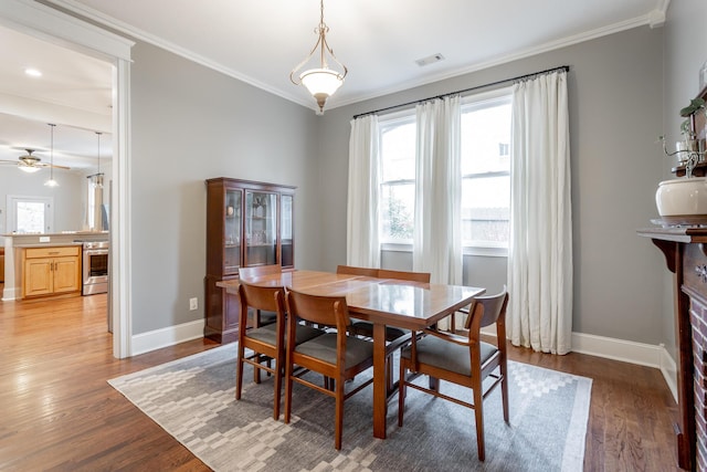 dining room featuring wood-type flooring, ceiling fan, and ornamental molding