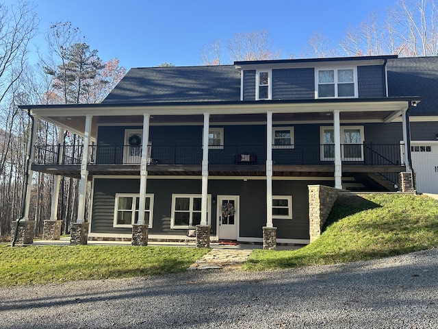 view of front facade with a balcony, covered porch, and a front yard