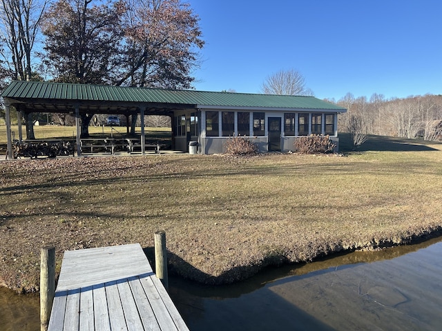 rear view of house featuring a sunroom and a yard