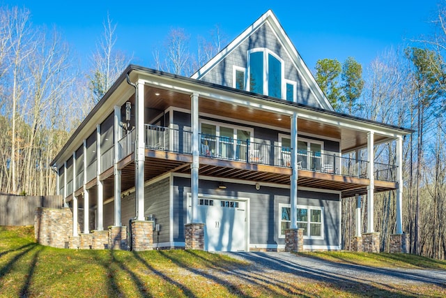 view of front facade featuring a balcony, a garage, and a front lawn