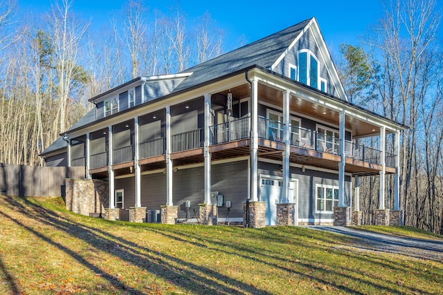 back of house featuring a lawn, a balcony, and central air condition unit