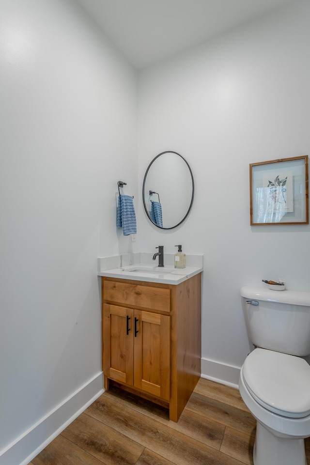 bathroom with vanity, hardwood / wood-style floors, and toilet