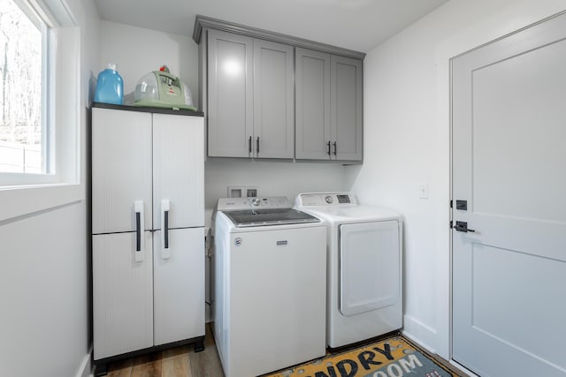 laundry room with cabinets, dark hardwood / wood-style flooring, and washer and clothes dryer