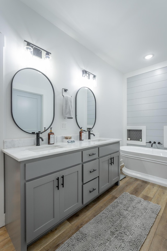 bathroom featuring a washtub, vanity, and wood-type flooring