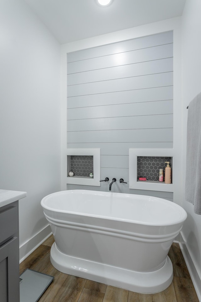 bathroom featuring a tub to relax in, hardwood / wood-style floors, and vanity