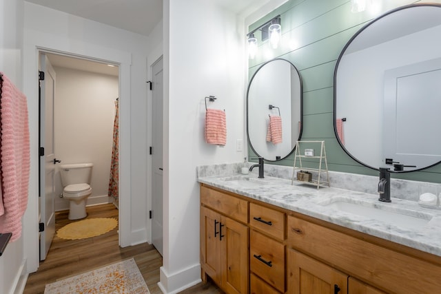 bathroom with vanity, hardwood / wood-style floors, wooden walls, and toilet