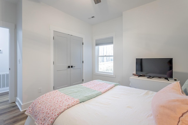 bedroom featuring light hardwood / wood-style floors, a closet, and ceiling fan