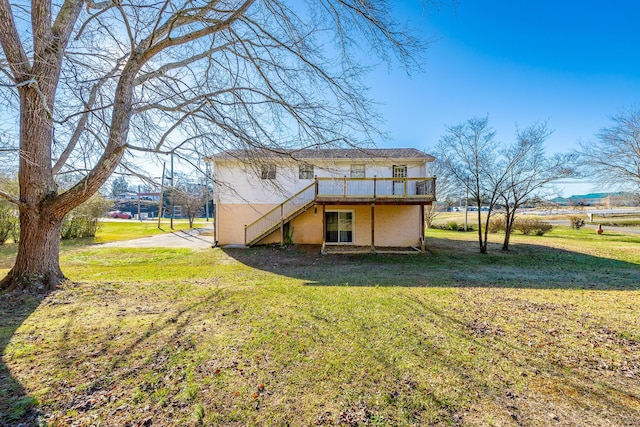 rear view of property with a yard and a deck