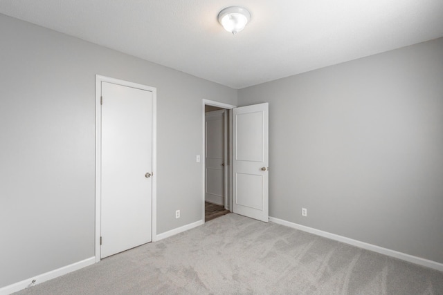 unfurnished bedroom with light carpet and a closet