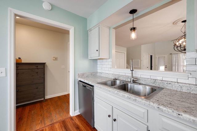 kitchen with tasteful backsplash, stainless steel dishwasher, sink, pendant lighting, and white cabinets