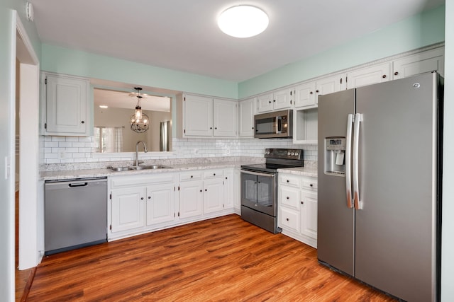 kitchen with appliances with stainless steel finishes, white cabinetry, and sink