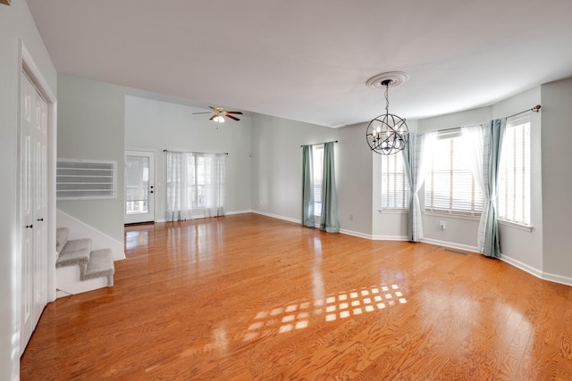 spare room featuring ceiling fan with notable chandelier and light hardwood / wood-style floors